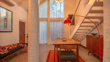 A cozy room with a wooden table, a bench, and a staircase.