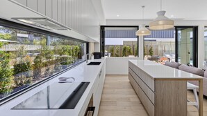 Een moderne keuken met een groot eiland, een ingebouwd aquarium en uitzicht op de achtertuin.