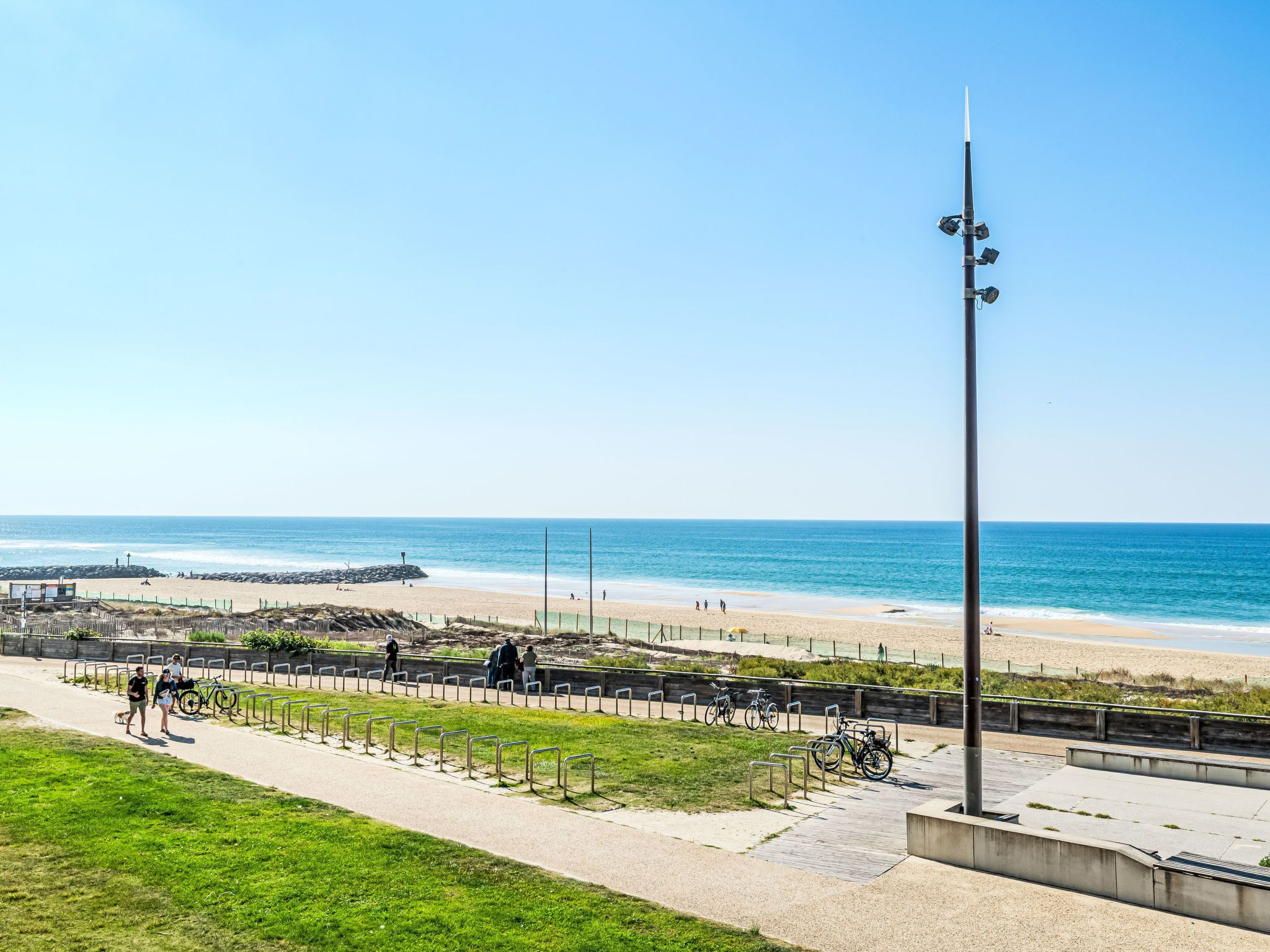 Ein Küstenweg mit Blick auf den Strand und das Meer.
