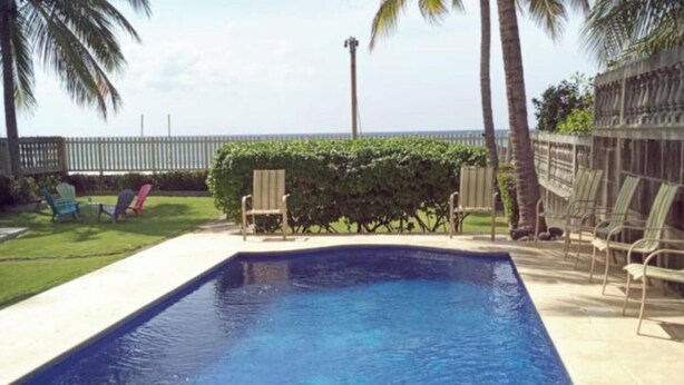A rectangular swimming pool with a clear blue water surface, surrounded by a tiled deck. -  Beach Front House in Tránsito Beach , 5-Bedrooms, AC ,with Beachfront  Pool. (El Tránsito)