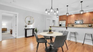 A modern kitchen with wooden cabinets, stainless steel appliances, and a central island. - The Juliette by AvantStay (Savannah)