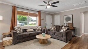 A living room with two sofas, a coffee table, a ceiling fan, and a view of the outside. - Cozy Ranch King Bed & Pet Friendly - Fenced Yard (Gahanna)