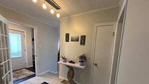 A hallway with a door, a small table with plants, and a rug. - 3BR Less then 5 minutes from Downtown, Hospitals & Mall (St. John's)