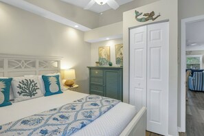 Une chambre à coucher comprenant un lit, une commode et une porte donnant sur une autre pièce.