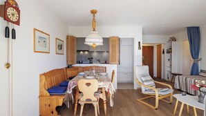 A cozy living room with a wooden bench, a dining table, and a kitchen in the background. - Cosy apartment for 4 people with WIFI, TV, balcony and panoramic view (Bluche)