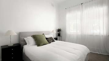 Tabla de planchar con plancha, internet y ropa de cama