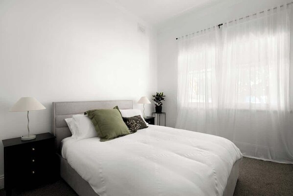 Tabla de planchar con plancha, internet y ropa de cama