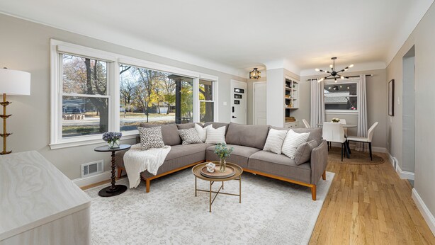 A modern living room with a sectional sofa, a round coffee table, and a dining area with a white table and chairs. - Clean & Cozy 4BR Retreat, Hot Tub, 1 Mile to DTP (Plymouth)