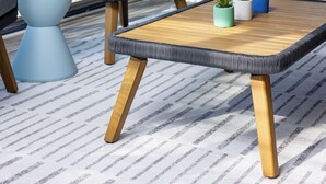 A modern outdoor seating area with a wicker chair, a round table, and potted plants. - Clean & Cozy 4BR Retreat, Hot Tub, 1 Mile to DTP (Plymouth)