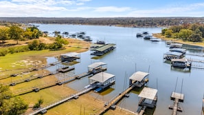 A marina with multiple docks and boats, surrounded by greenery and a distant tree line. - Bixby Cove Cabin #1 (Porum)