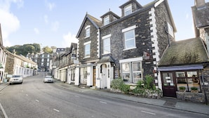 A street view with stone buildings, a clear sky, and parked cars. - Ambleside Guest House (Ambleside)