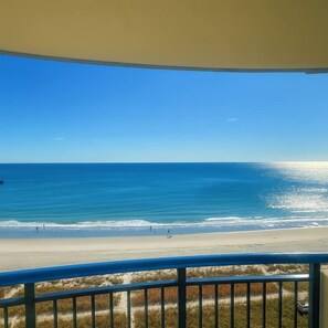 Une vue sur la plage depuis un balcon doté d’une balustrade.