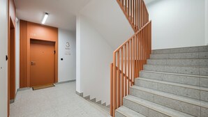 A modern interior with a staircase, a door labeled "3 metro 116-118", and a clean, tiled floor. - Praga Południe Homely Apartment (Warszawa)