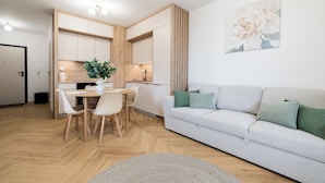 A modern apartment with a dining area, kitchen, and living room. - Posnania Deluxe Apartment (Poznań)