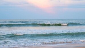 Une plage avec des vagues et un ciel dégagé.
