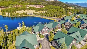 A resort with multiple buildings, a lake, and mountains in the background. - NEW! Ski-In/Out, Lone Peak & Lake Views, 3B/3B (Big Sky)