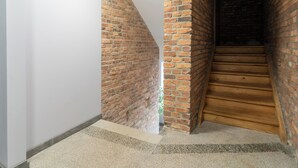 A staircase with wooden steps and brick walls. - Fabryczna City Apartment (Katowice)