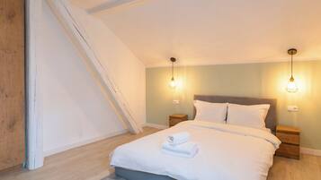 A bedroom with a bed, two bedside tables, and a nightstand.