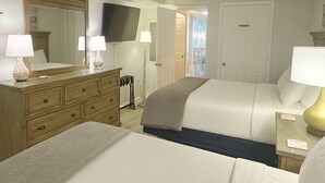 A hotel room with two beds, a ceiling fan, a TV, and a large mirror. - PALM TREE PARADISE/PRIME LOCATION (Myrtle Beach)