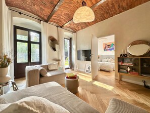 A spacious living room with a brick ceiling, large windows, and a cozy seating area. - Szczytnicka 29 Superior Apartment (Wrocław)