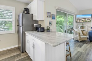 A modern kitchen with a large island, white cabinetry, and a built-in oven. - Perfect for large groups, Steps to the Beach. Private Pool & Putting Green. (Siesta Key)