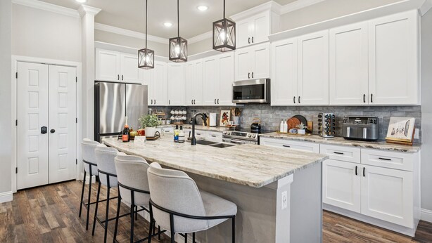 A modern kitchen with white cabinetry, a large island with bar stools, stainless steel appliances, and pendant lighting. - The Oakwood Villa - Ultimate Texas 4 BR Ranch with Pool 35 min to AT&T Stadium (Mansfield)