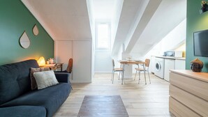 Eine moderne Wohnung mit Essbereich, einer Küchenzeile und einem Wohnraum mit Sofa und Couchtisch.