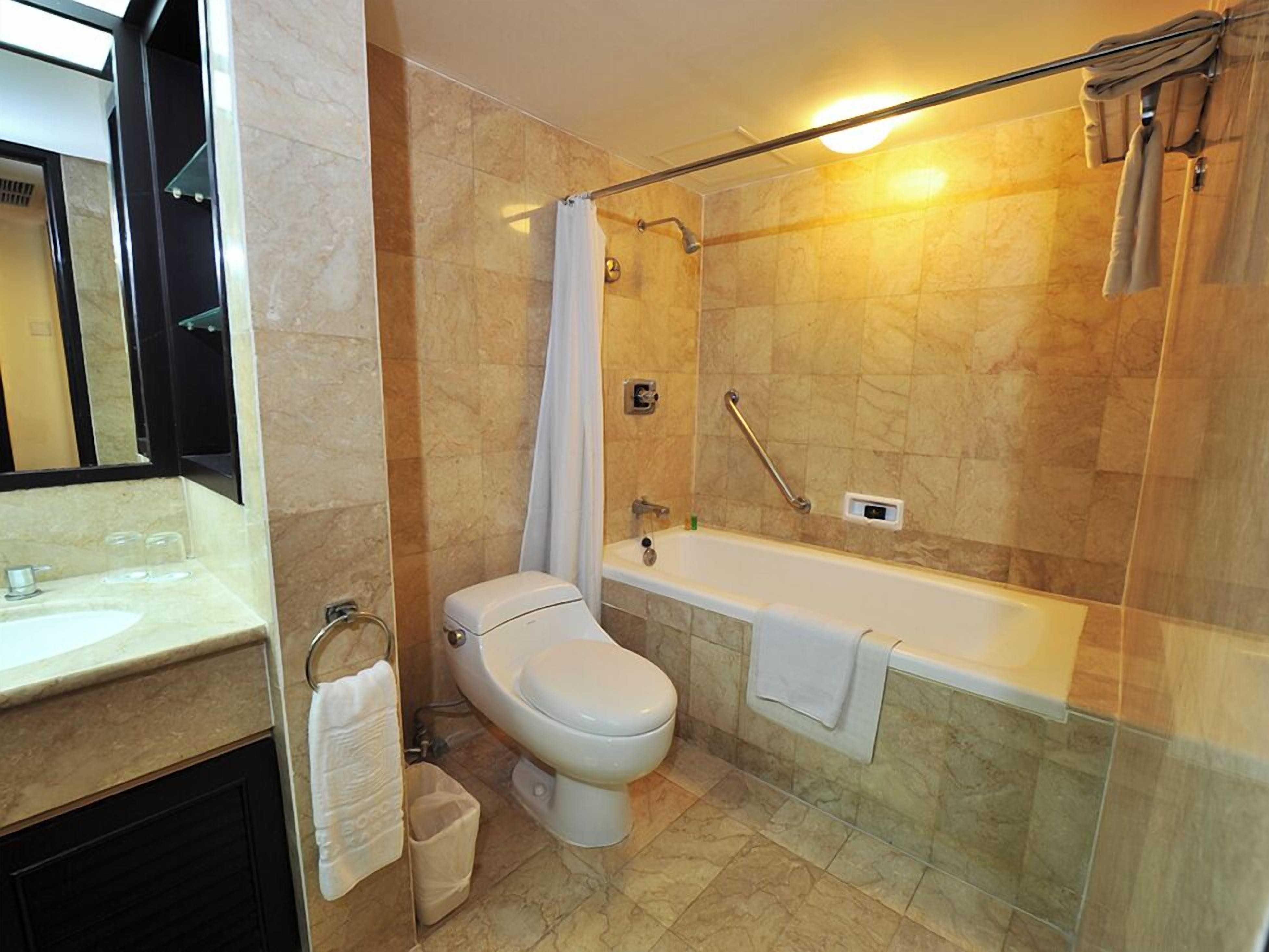 Une salle de bain moderne équipée de toilettes, d’un lavabo et d’une baignoire.
