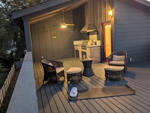 Una terrassa exterior amb mobles de vimet, una barbacoa i una taula de vidre.