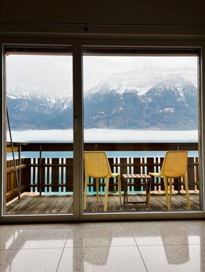 A room with a view of snow-capped mountains through large windows.
