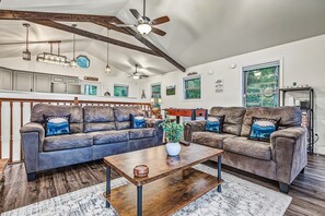 A spacious living room with two leather sofas, a wooden coffee table, and a ceiling fan. - Hot Tub, Mtn Views & EV Charger, 1.5mi to Gatlinburg Strip (Gatlinburg)