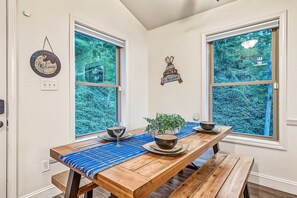Dining table with bench seating & wooded window views - Hot Tub, Mtn Views & EV Charger, 1.5mi to Gatlinburg Strip (Gatlinburg)