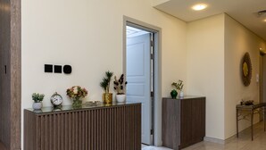 Un'area reception con una scrivania in legno, una sveglia e vasi decorativi.