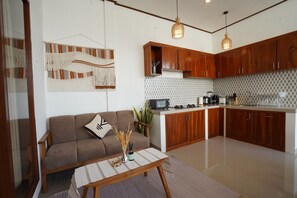 Une cuisine moderne avec des meubles en bois, un four à micro-ondes et une machine à café.