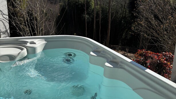 Un jacuzzi con una vista despejada de montañas y árboles al fondo.
