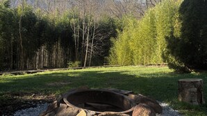 Un hogar rodeado de rocas y grava, con un área de césped y árboles al fondo.