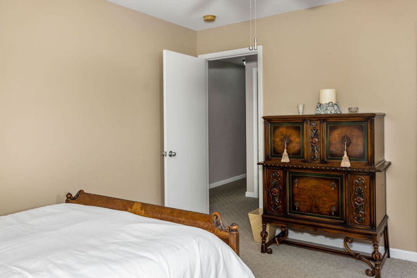 Ein Schlafzimmer mit einem hölzernen Bett, einem Schminktisch und einem Kleiderschrank.