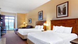 A hotel room with two beds, a desk, a chair, a lamp, and a window. - Karmak 2 bedroom condo on the first floor. (Wisconsin Dells)