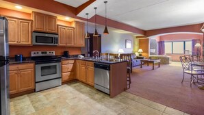 A modern kitchen with wooden cabinets, stainless steel appliances, and pendant lighting. - Karmak 2 bedroom condo on the first floor. (Wisconsin Dells)