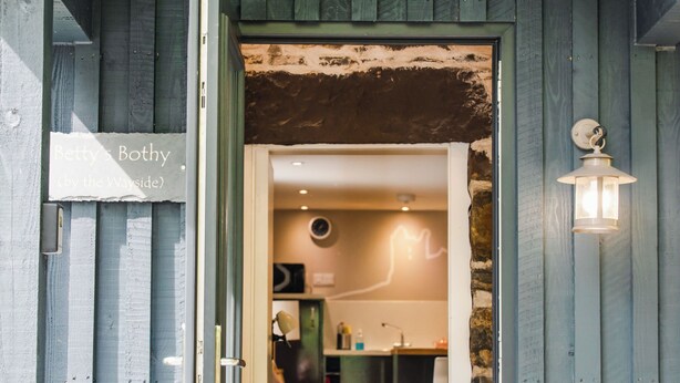 A wooden exterior with a sign reading "Betty's Bothy (by the Wayside)". - Wayside Bothy by Interhome (Drumnadrochit)