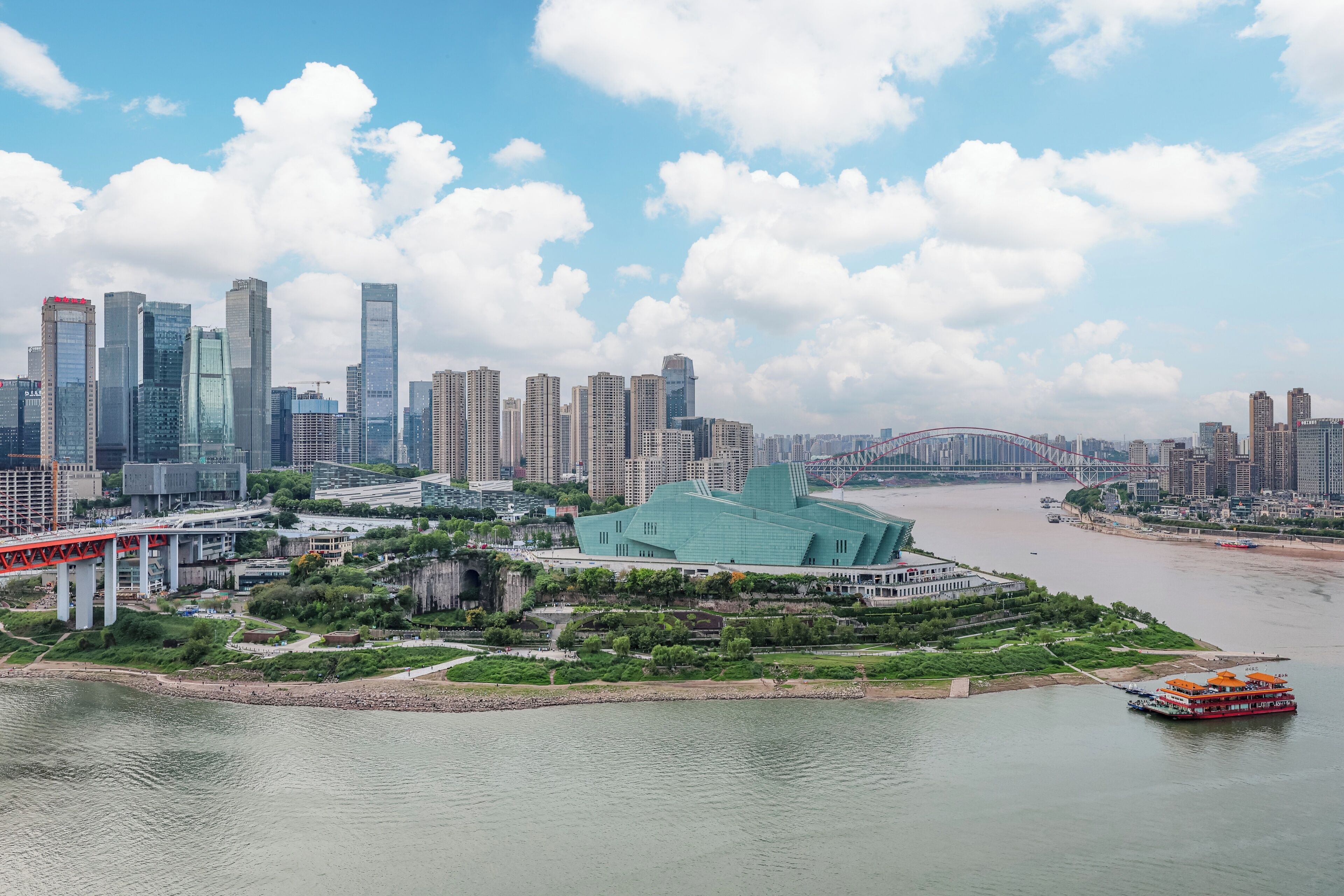 A cityscape with modern buildings, a river, and a bridge.