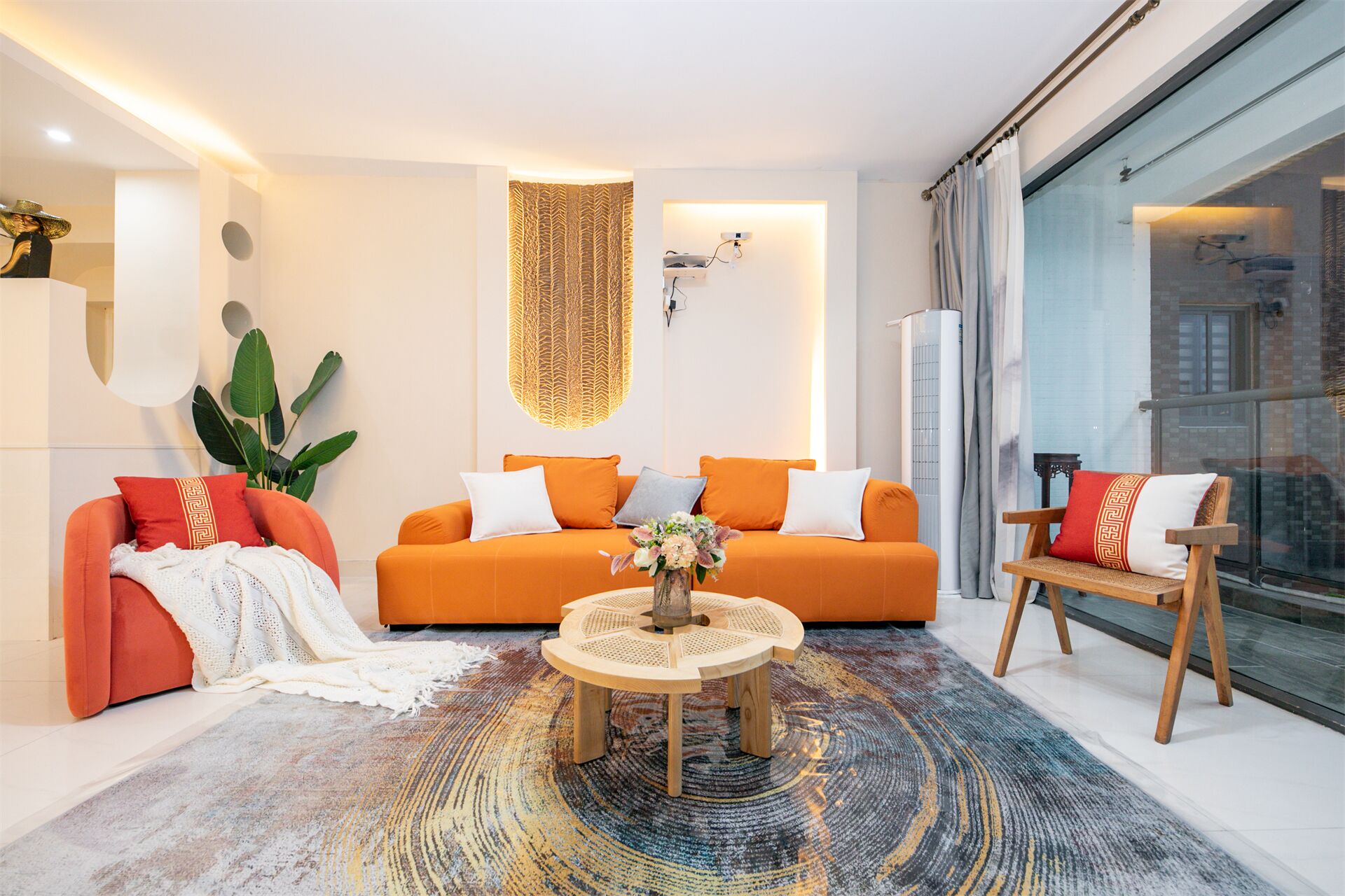 A modern living room with a sofa set, a coffee table, and a large window.