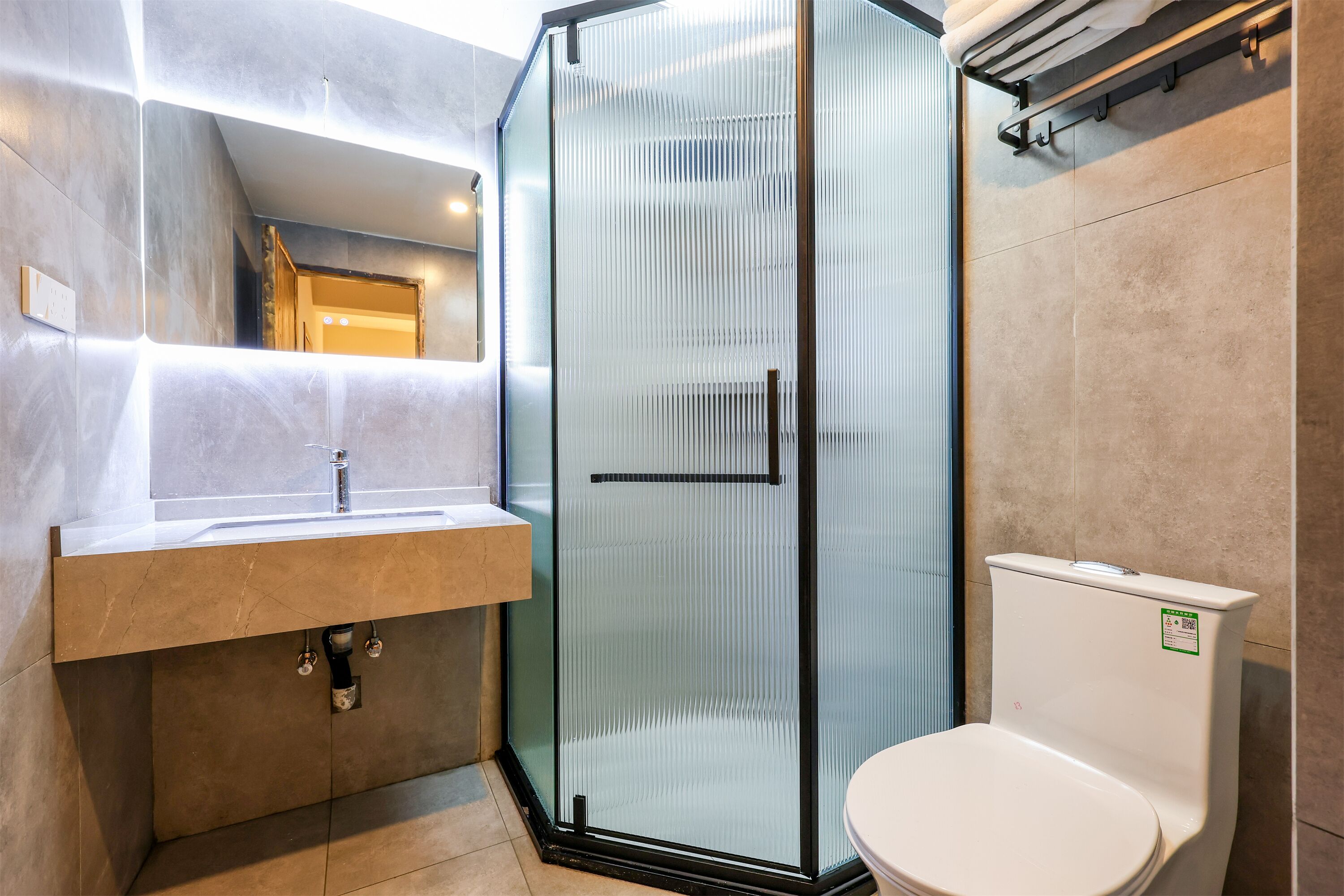 A modern bathroom with a glass shower enclosure, a sink with a countertop, and a toilet.