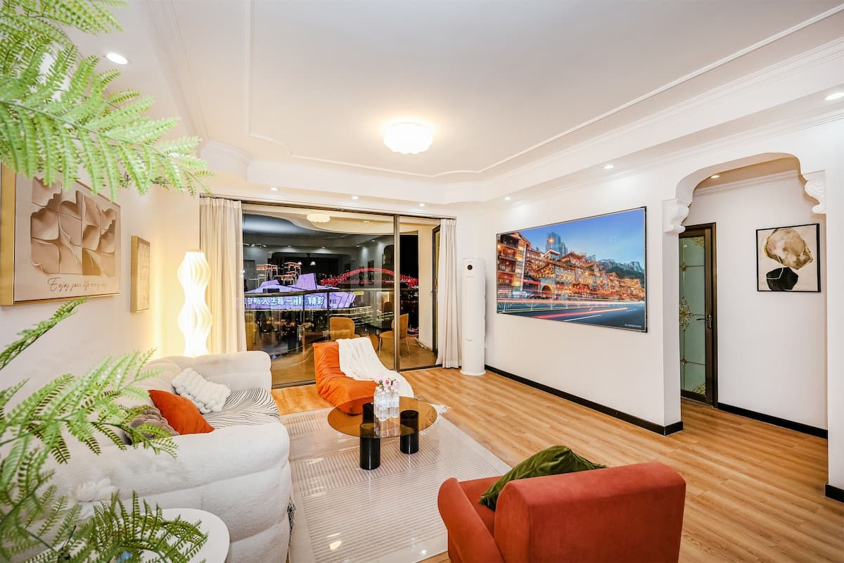 A modern hotel lobby with a seating area, a large window, and a painting of a cityscape.