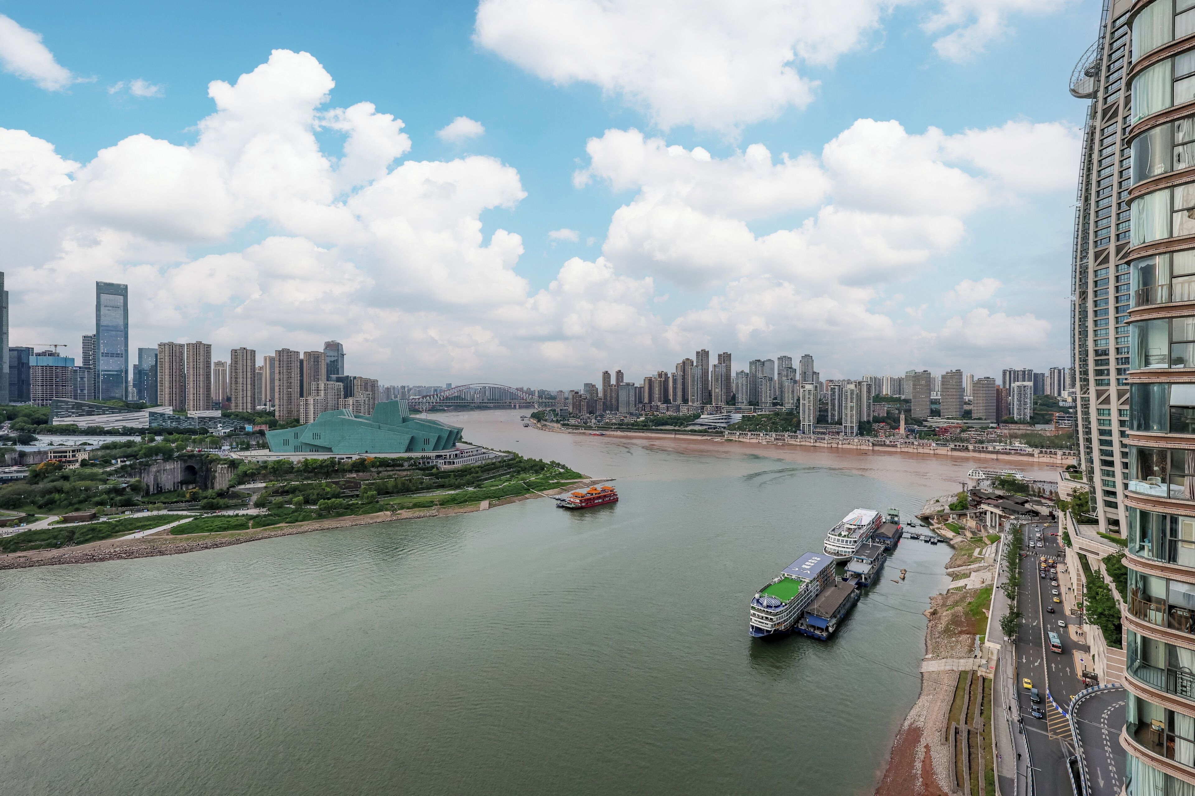 A river with boats, a bridge, and a city skyline with high-rise buildings.