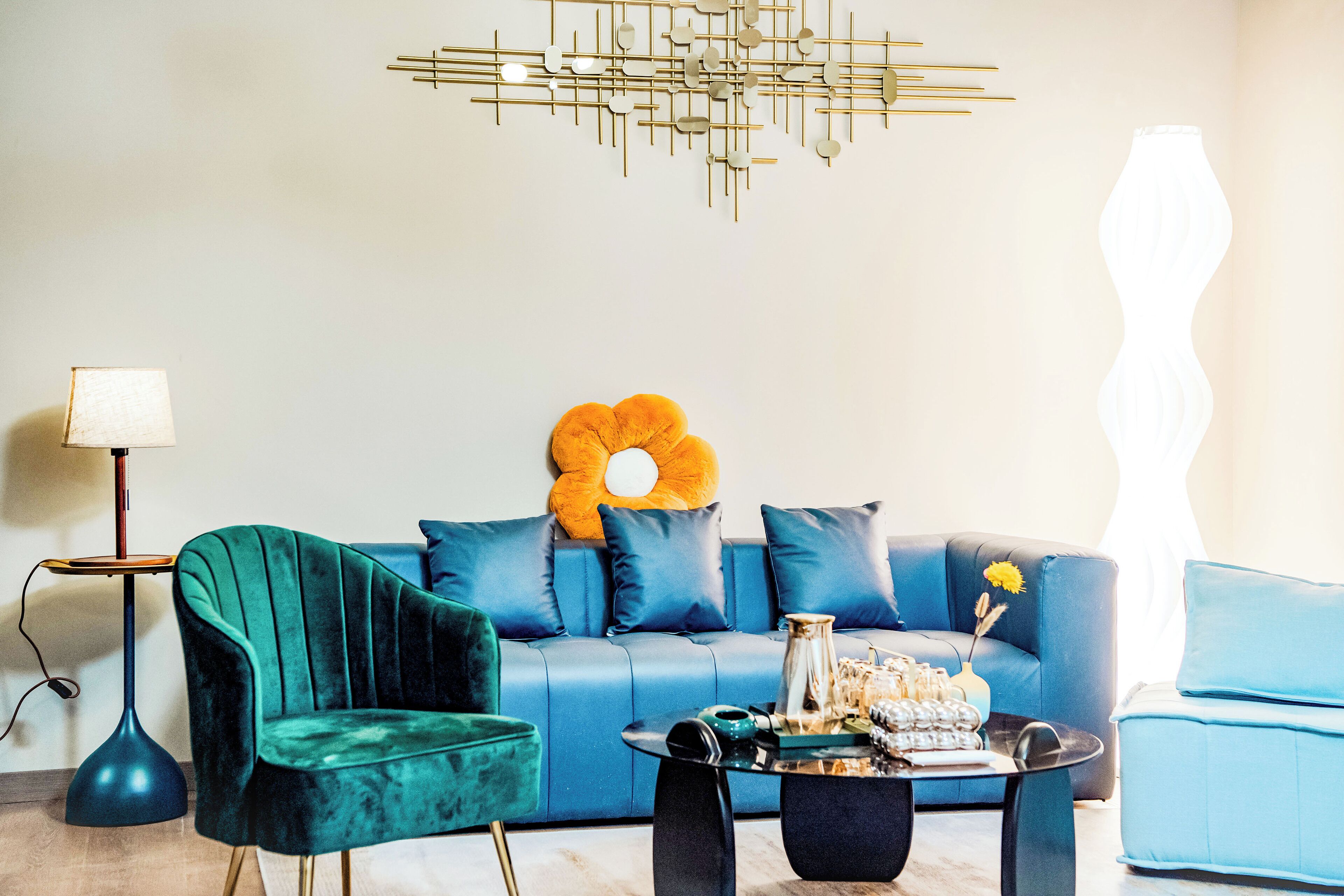 A modern living room with a blue sofa, a green armchair, and a coffee table.