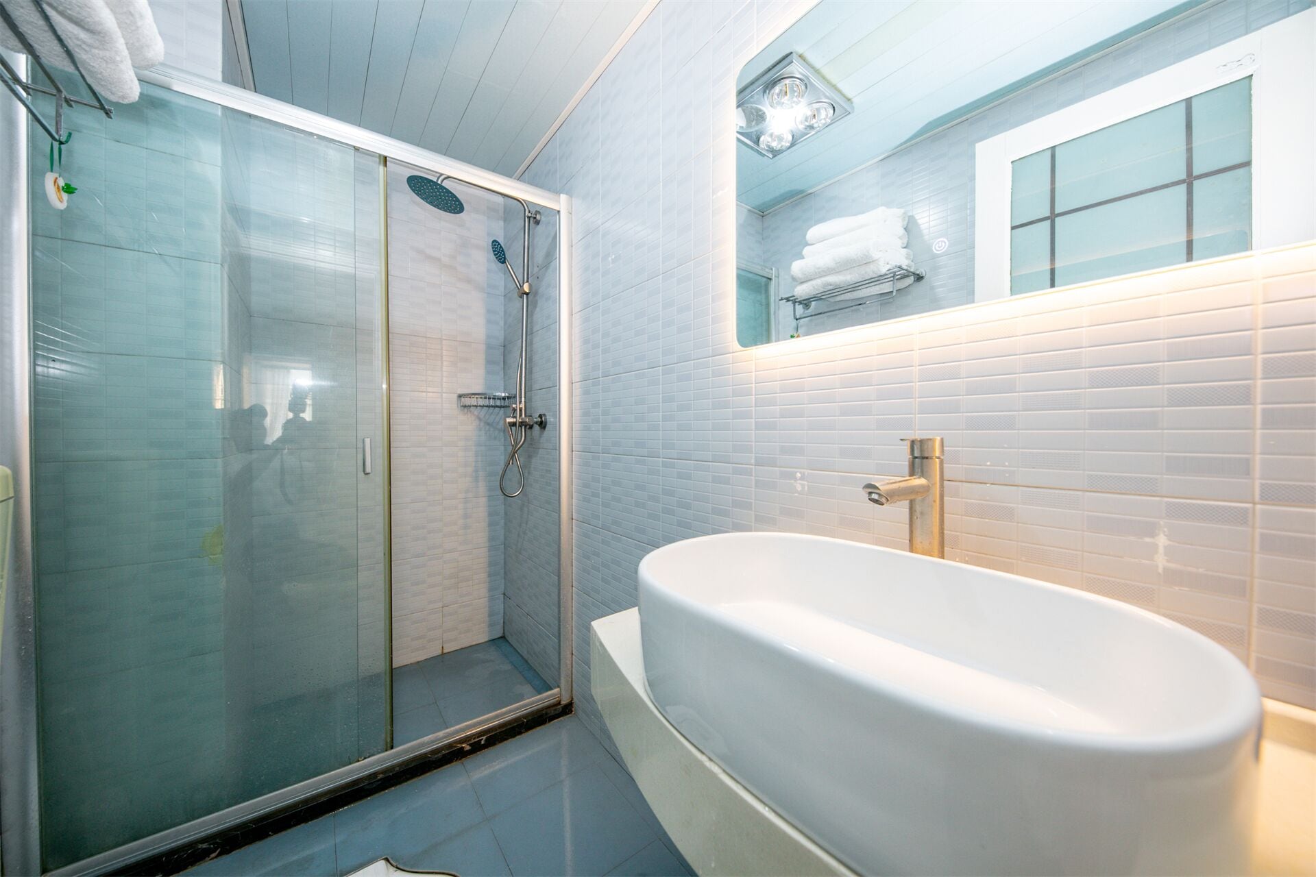A bathroom with a glass-enclosed shower, a freestanding bathtub, and a mirror above the sink.