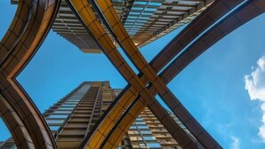 Un immeuble de grande hauteur doté d’une architecture moderne, caractérisé par une structure en forme de X bien visible et par de nombreux étages avec des fenêtres apparentes.