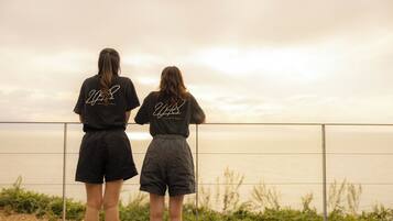 Two people standing on a balcony overlooking a body of water.