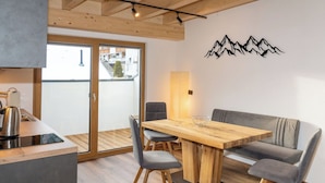 Et moderne køkken med elkedel, et træspisebord og en sofa.